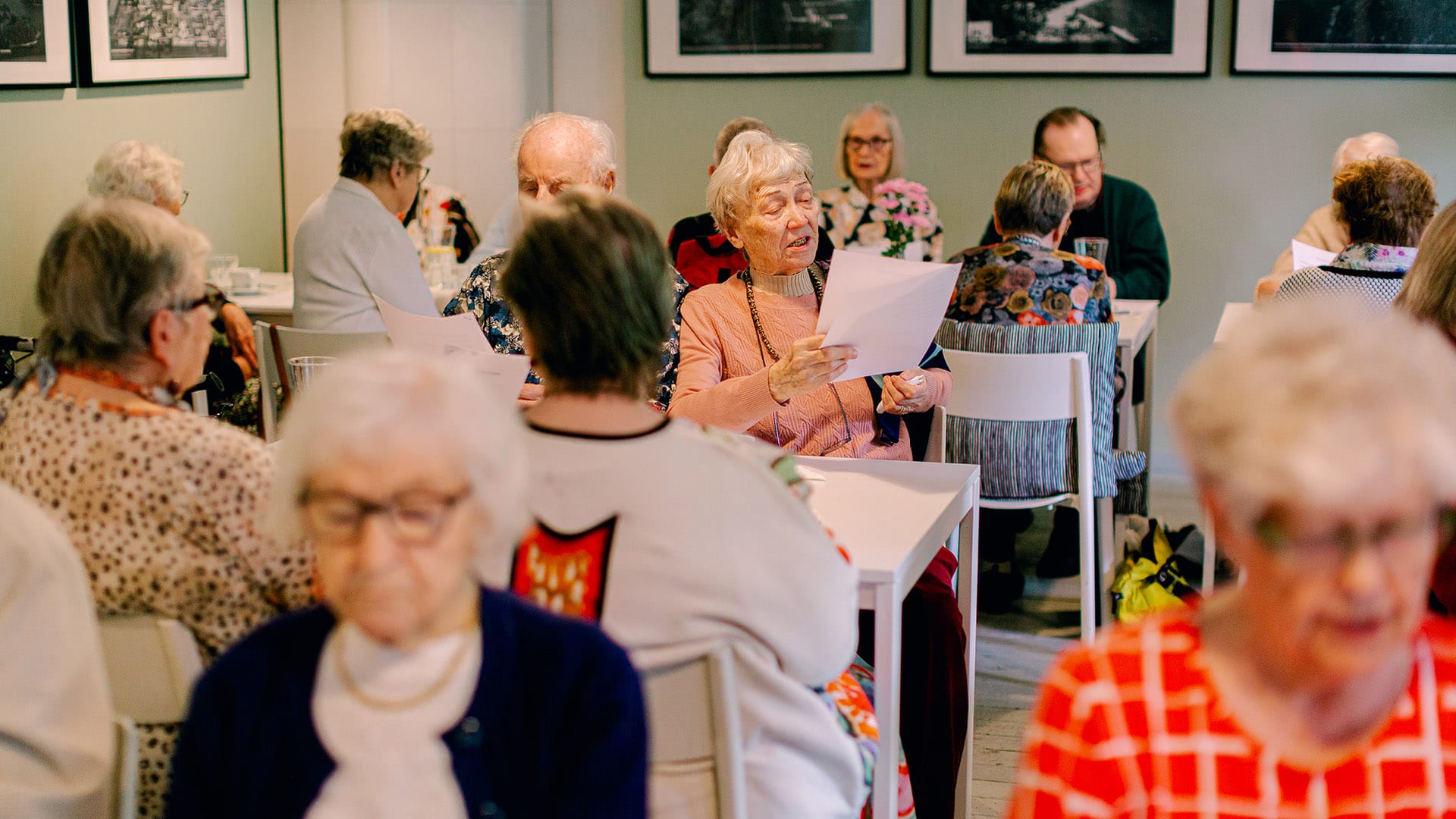 Senioritalo Cecilian asukkaat laulavat kesäjuhlissa Rastilan kartanon salissa.
