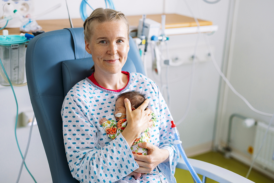 Perhekaveri sylittelemässä vauvaa.