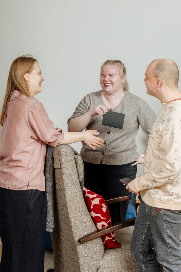 Kolme ihmistä juttelee keskenään nauraen.